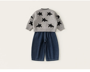 Achteraanzicht van grijze gebreide trui met zwarte ster en blauwe denim broek met wijde pijpen