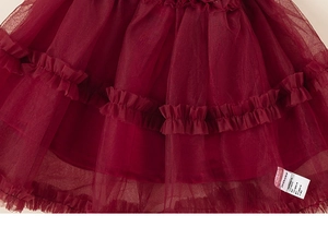 Macro detail of wine red layered mesh tulle fabric with elegant ruffled textures