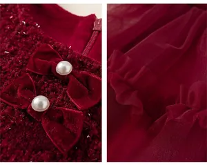Close-up of velvet bows with pearls and layered red mesh gauze on the dress