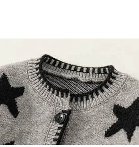 Detailopname van grijs gebreid vest met zwart sterpatroon en glanzende knoop