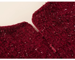 Detailed macro view of dark red tweed fabric with metallic glitter and invisible zipper