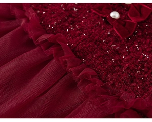 Detailed macro view of red tweed fabric with velvet bow and pearl button accent