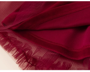 Close-up detail of deep red tulle layers and fine stitching on the girls' princess dress