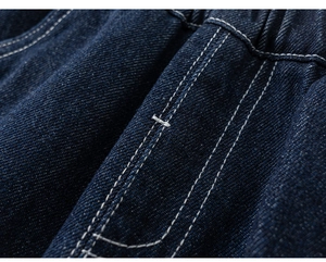 Detail van donkerblauw denim jack met contraststiksels en elastische taillebandtextuur