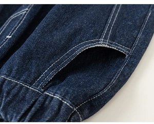 Detailopname van donkerblauwe denim met witte contraststiksels en een handige zijzak