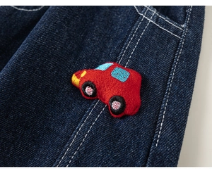 Detail van rood 3D-auto borduursel op donkerblauwe denim stof voor kinderkleding