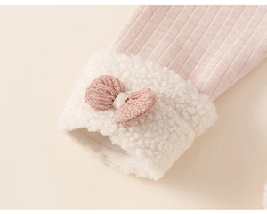 Detailopname van roze geribbelde mouw met witte sherpa omslag en een decoratieve strijk