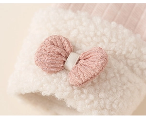 Detail van roze geribbelde gebreide stof met witte pluche rand en strikdecoratie