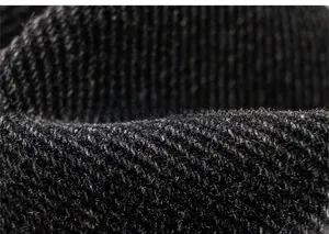 Macro close-up of high-quality black denim fabric with detailed diagonal twill weaving