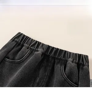 Close-up of flexible elastic waistband on girls dark grey denim jeans for comfort