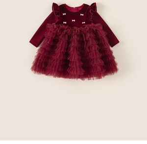 Détail du corsage en velours rouge avec nœud doré et tulle multicouche sur robe de fille