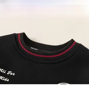 Détail de l'encolure côtelée avec rayure rouge et broderie sur sweat-shirt enfant