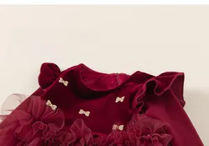 Détail de robe en velours rouge pour fille avec boucle nœud et volants en tulle