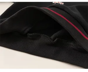 Détail de l'ourlet élastique côtelé du sweat-shirt noir avec rayures rouges