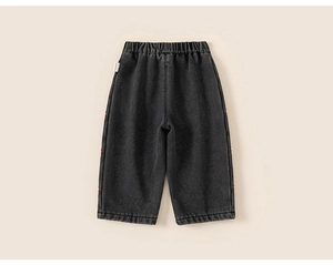 Detailed view of girl's dark grey straight jeans with elastic waist and red embroidery