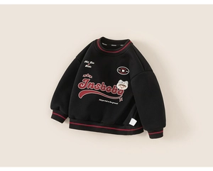 Détail d'un sweat-shirt noir pour enfant avec broderie rouge et poignets rayés