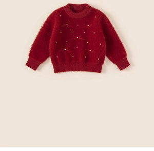 Detailed macro view of girls' red knit sweater with pearls and ribbons