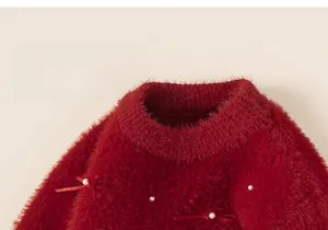 Close-up of red knit sweater featuring delicate bows and white pearls detail