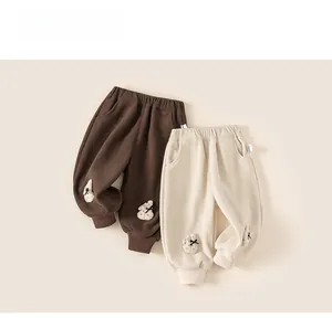 Détail de pantalons en velours côtelé pour filles en café et beige avec écussons lapin