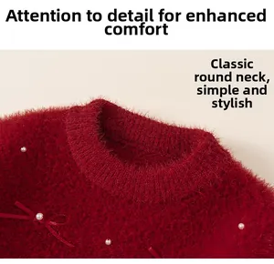 Close-up of girls red plush sweater featuring a pearl neckline and ribbon bow detail