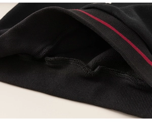 Gros plan sur les poignets côtelés noirs d'un sweat-shirt avec rayures rouges sport
