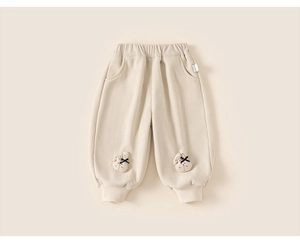 Détail du pantalon en velours côtelé beige pour enfants avec écussons lapin et bords-côtes