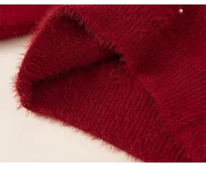 Detail view of the loose hem on this warm red plush girl sweater with soft faux fur texture