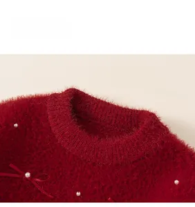 Close-up of red mink faux fur sweater with white pearls and delicate ribbon bows
