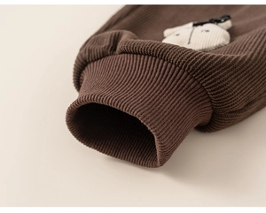 Détail du pantalon en velours côtelé marron avec écusson lapin et nœud pour enfant