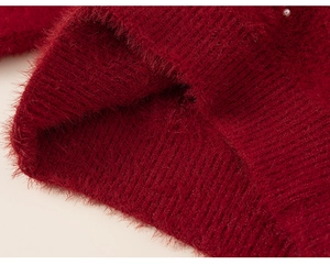 Detail of red plush knit texture with soft faux mink fur and a white pearl accent