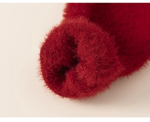 Close-up of deep red faux mink fur texture on soft girl's long sleeve knitted sweater
