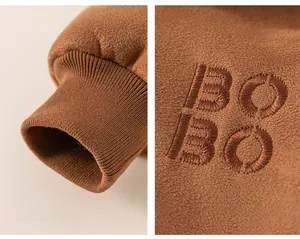 Close-up of brown fleece winter coat featuring BOBO letter embroidery and ribbed windproof cuffs