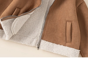 Detailansicht der braunen Mädchen-Wildlederjacke mit weißem Lammfellfutter und Reißverschluss