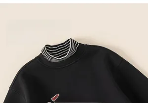 Detail of boys' black sweatshirt with sporty print and striped mock neck collar