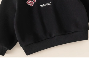 Close-up of black kids sweatshirt showing ribbed hem and INSBOBO street style print