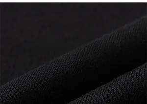 Detailed close-up showing the soft black knitted cotton fabric texture and fine stitching