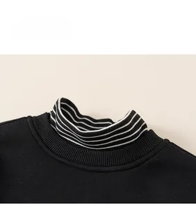 Close-up of black sweatshirt collar with striped turtleneck layer and knit texture
