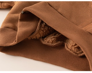 Detail of boys winter jacket showing brown faux suede fabric and warm shearling lining