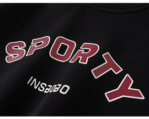 Detail of a black cotton kids sweatshirt showing the ribbed neckline and sporty printing