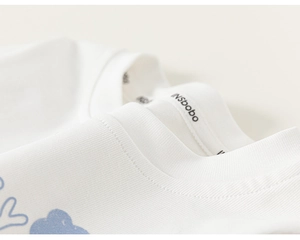 Close-up of a white cotton kids T-shirt featuring a blue cloud print and round neckline