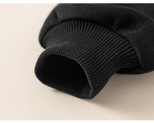 Close-up of black ribbed knit cuffs on a children's striped layered sweatshirt