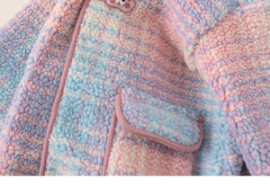 Detail of soft rainbow fleece jacket featuring a pink pocket and animal embroidery