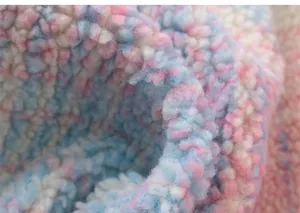 Macro shot of fluffy pink and blue rainbow sherpa fleece fabric showing soft texture