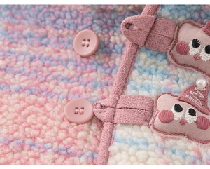 Macro detail of plush rainbow fleece fabric with pink star patch and round buttons