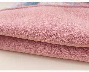 Close-up of soft pink plush fabric with premium stitching and colorful patterns