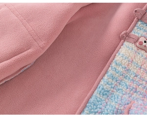 Detail of pink fleece girl's jacket with soft rainbow plush lining and animal embroidery