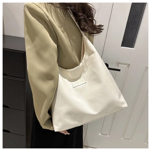 Close-up of cream faux leather tote bag with Fashion & Bags label on a shoulder strap