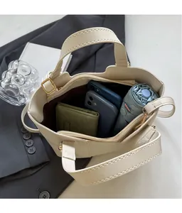 Vista dall'alto della spaziosa borsa tote in pelle PU crema con telefoni e ombrello dentro