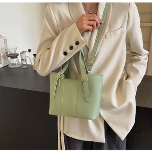Dettaglio della borsa tote verde menta con cuciture decorative e finiture dorate con tracolla