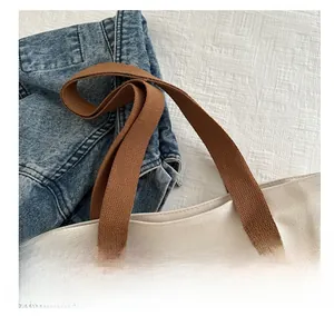 Détail des poignées en tissu marron durable et des coutures du sac fourre-tout